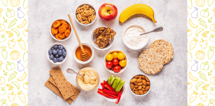 A marble tabletop with a selection of fruits, vegetables, nuts, crackers, and dips.