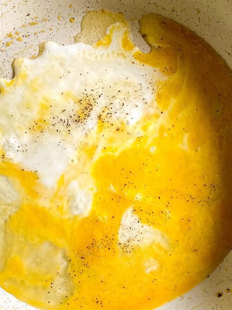 Partaly cooked egg on the bottom of a frying pan.