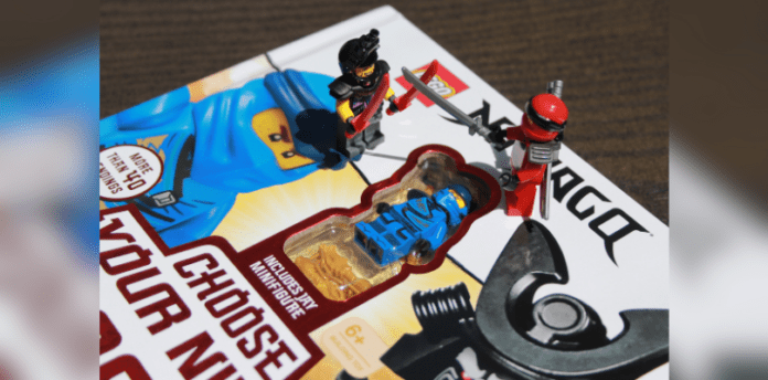Three LEGO Ninjago figures stand on the cover of a LEGO Ninjago book